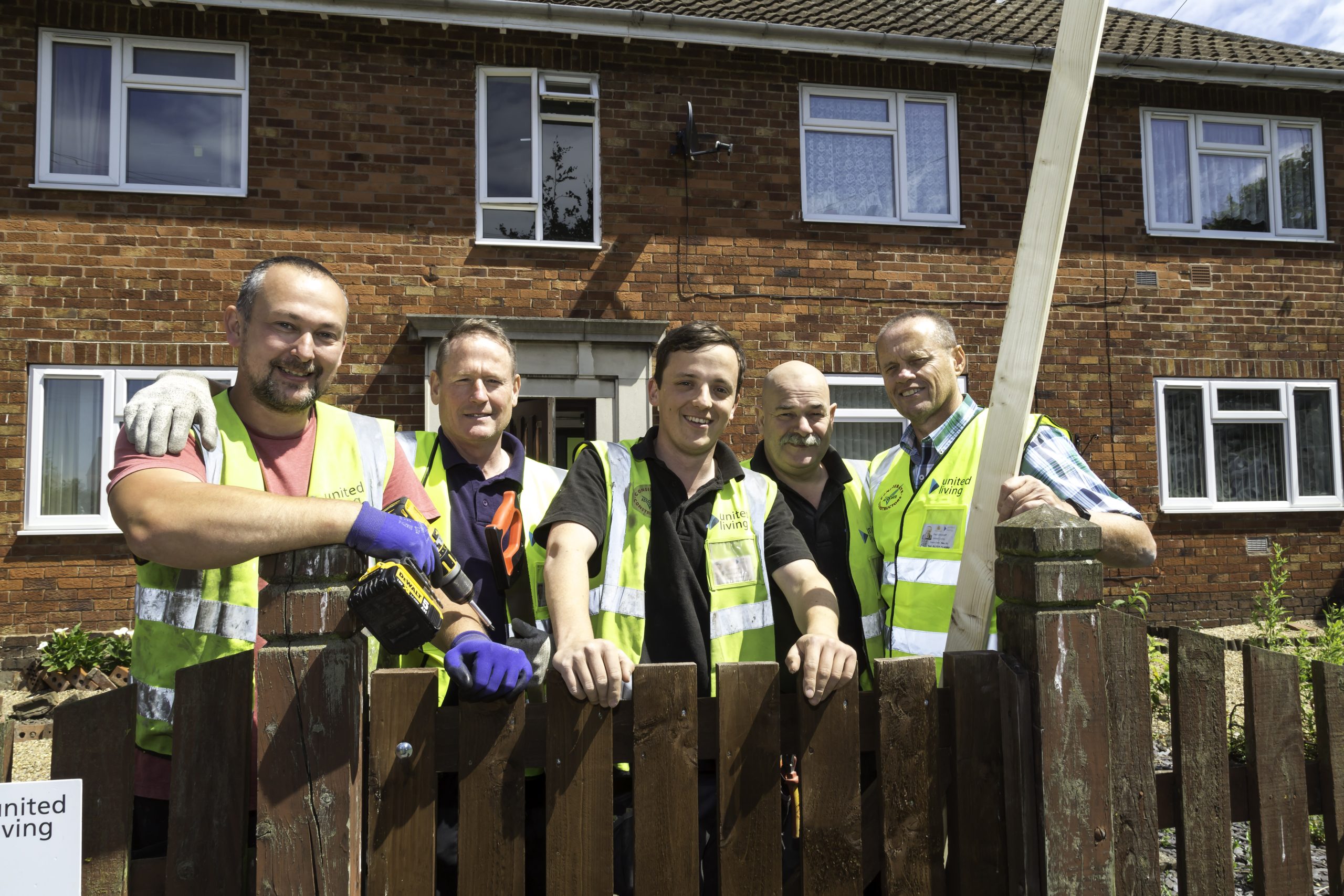 construction workers posing in front of house