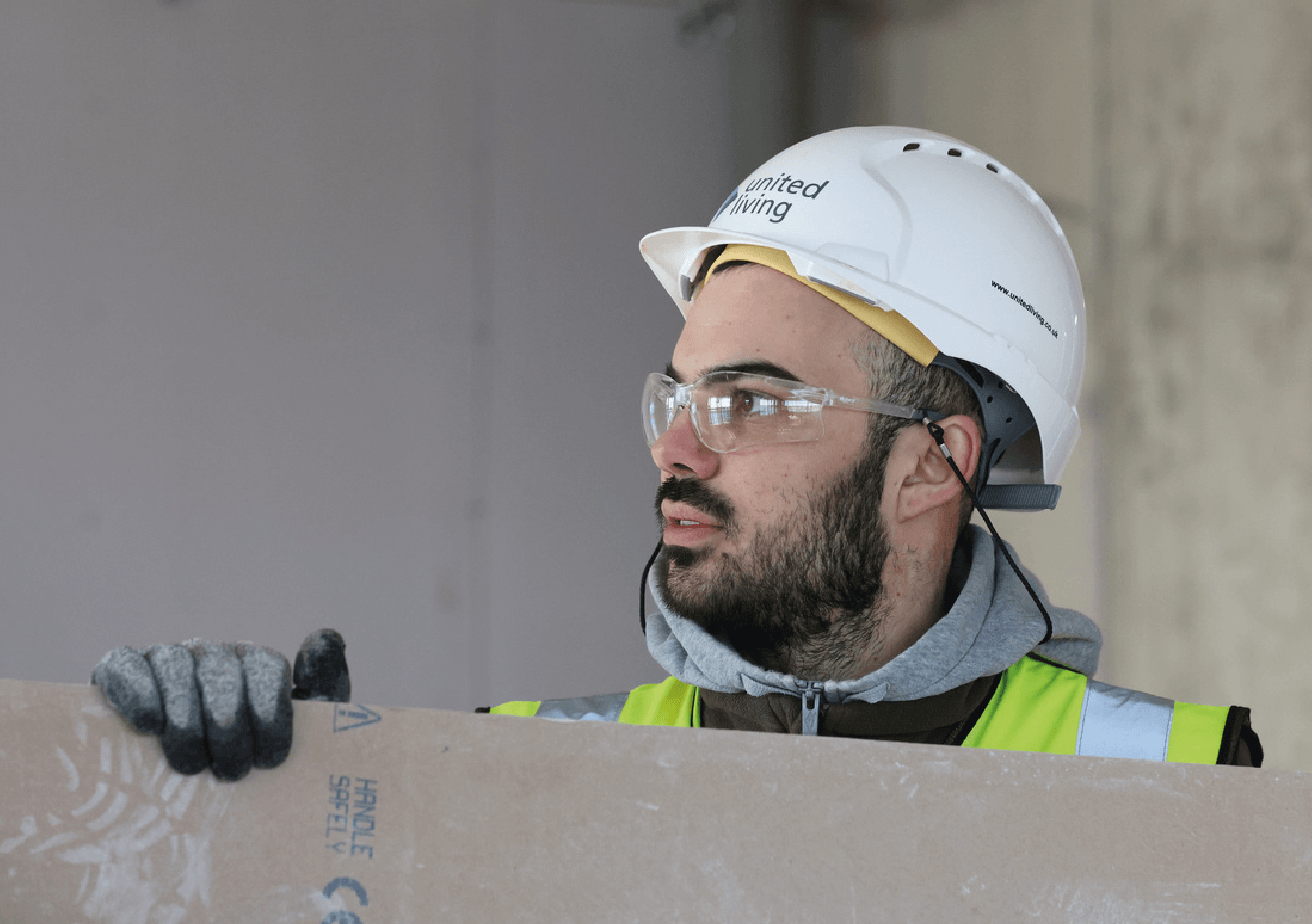 workman moving boarding on construction site