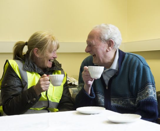 united living employee having a cup of tea with resident