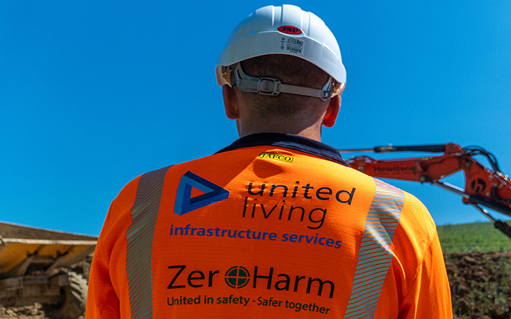 construction worker on sight overlooking digger